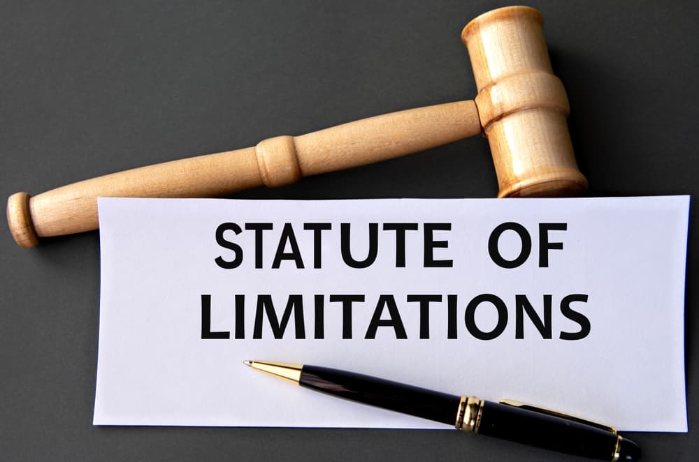 The phrase "STATUTE OF LIMITATIONS" is written in bold. Beside it rests a judge's gavel, symbolizing the legal implications and urgency associated with filing claims within the legally prescribed time limits.