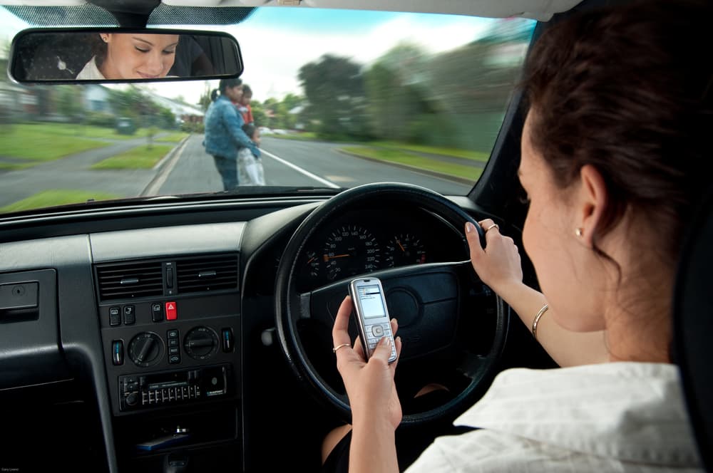 Texting while driving is a dangerous distraction, involving visual, manual, and cognitive distractions that impair a driver's focus and reaction time.