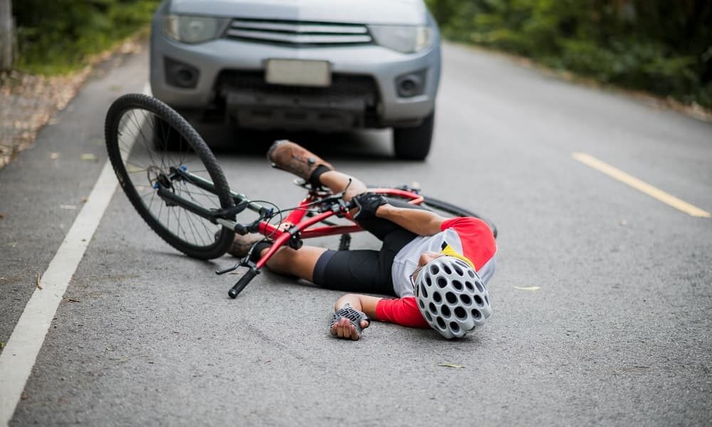 An Asian mountain biker collided with a car on the road and was injured in the accident.