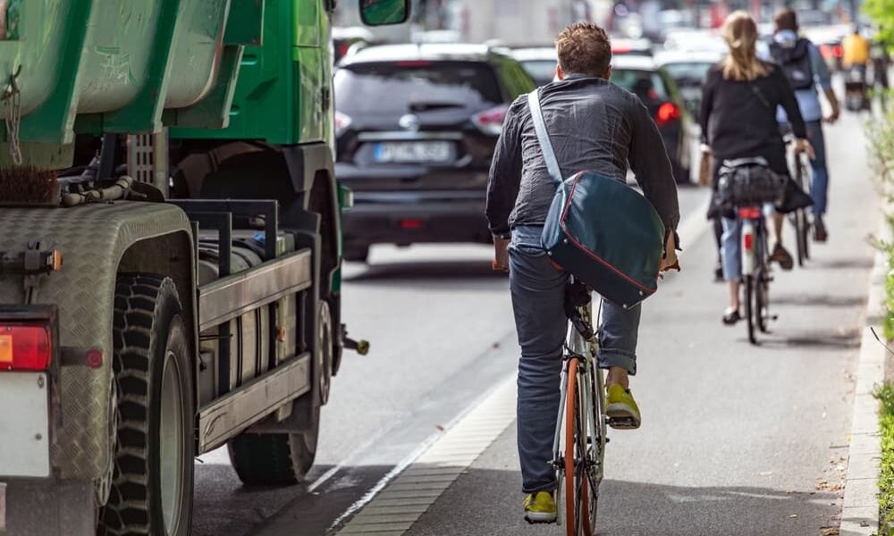 Cyclists on painted bike lane next to truck