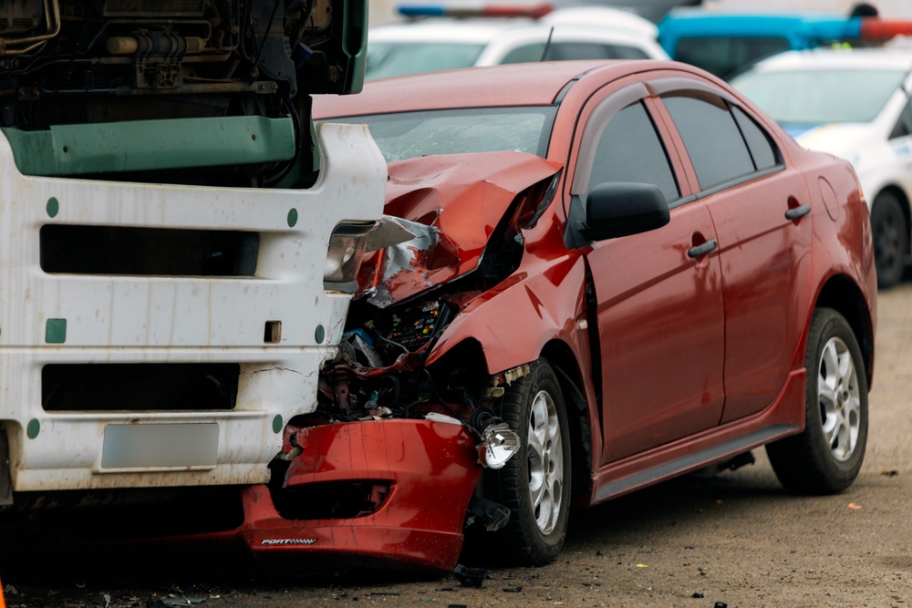 Crashed red car and bus after a collision, illustrating a bus accident in Bellevue