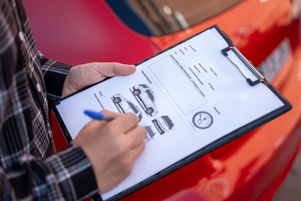 Insurance adjuster examining vehicle damage report, illustrating underinsured motorist claim handling in Bellevue.