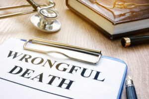 Document labeled &lsquo;Wrongful Death&rsquo; on a clipboard beside a stethoscope and legal materials, symbolizing a wrongful death claim.