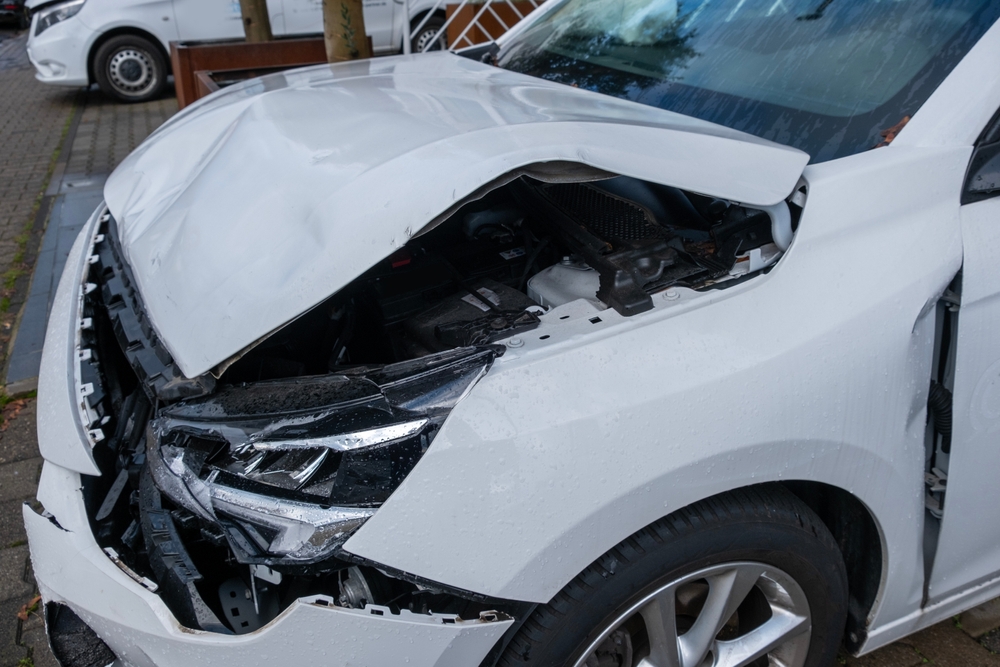 White car with severe hood damage after a hit and run collision